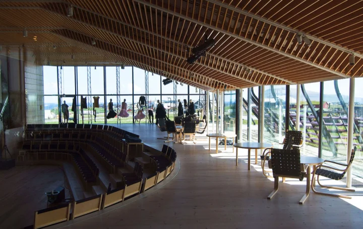 Scandinavian style chairs and tables in the Nordic House, with a view of the city of Tórshavn